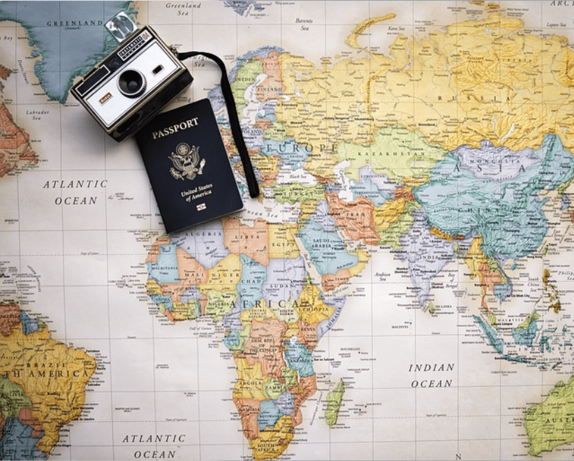 Picture of a world map, camera, and passport.